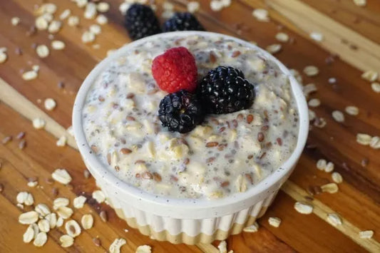 Bol dans lequel il y a overnight oats avec framboises, vu du dessus sur une table